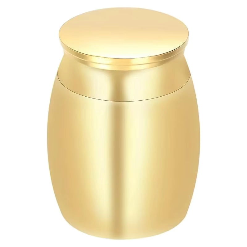 A small metallic gold cremation urn with a rounded body and a flat, slightly domed lid, shown on a plain white background.